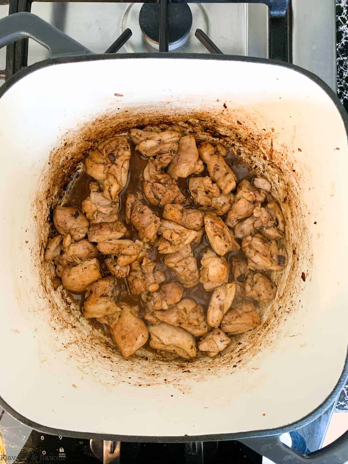 Chicken pieces browning in a Dutch oven.