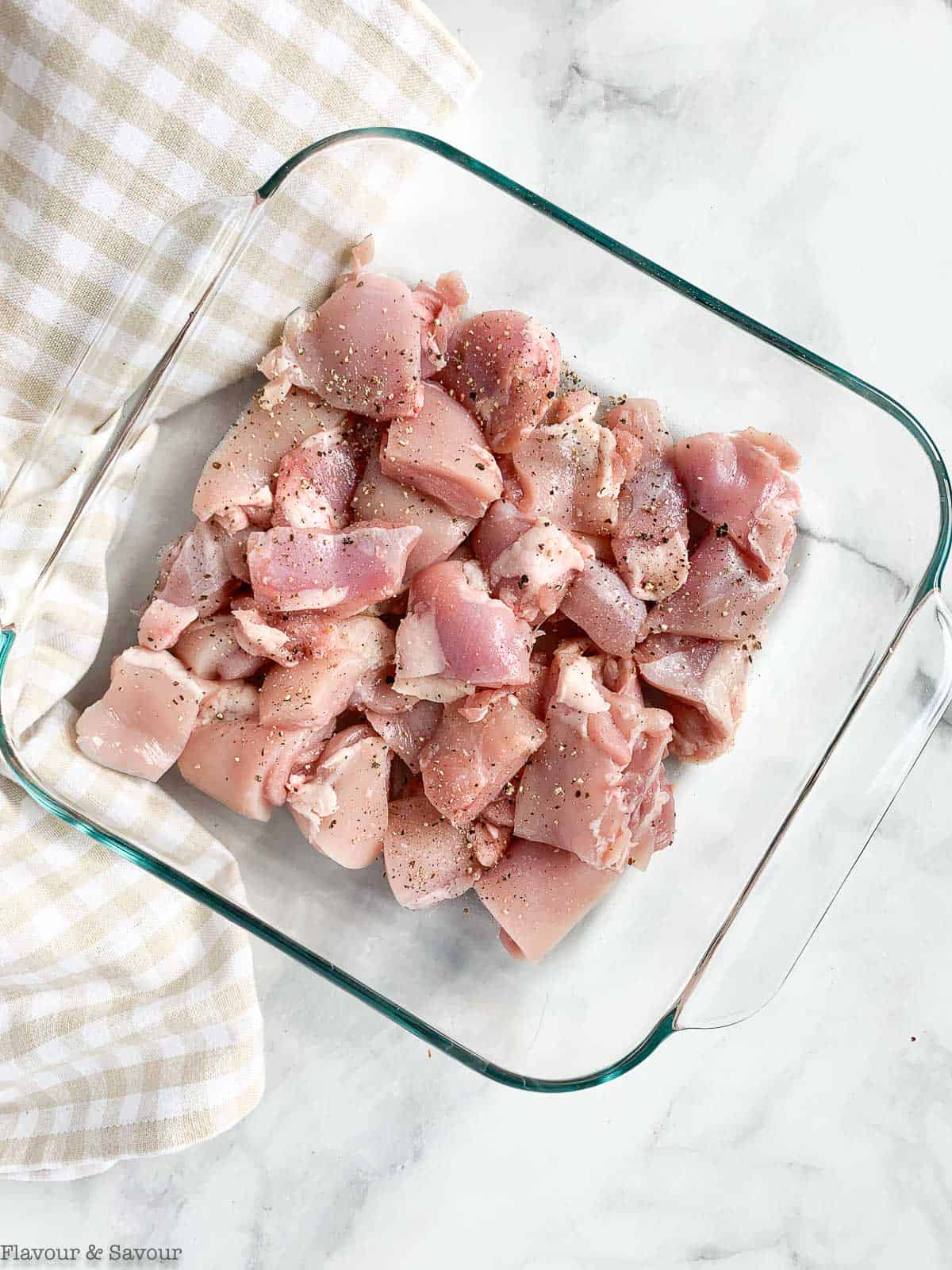 Raw chicken in a glass dish.