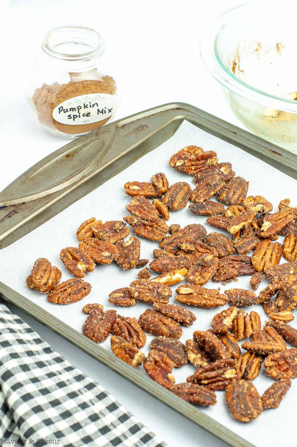 Roasted pumpkin spice pecans on a baking sheet.