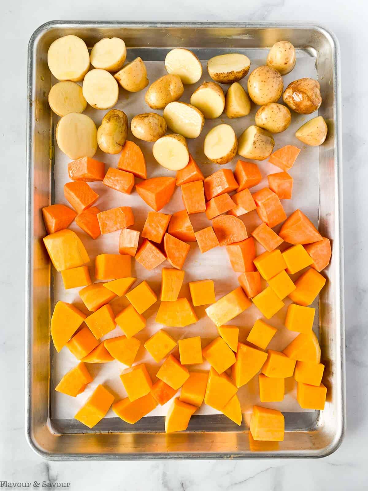 Root vegetables on a baking sheet ready to roast.