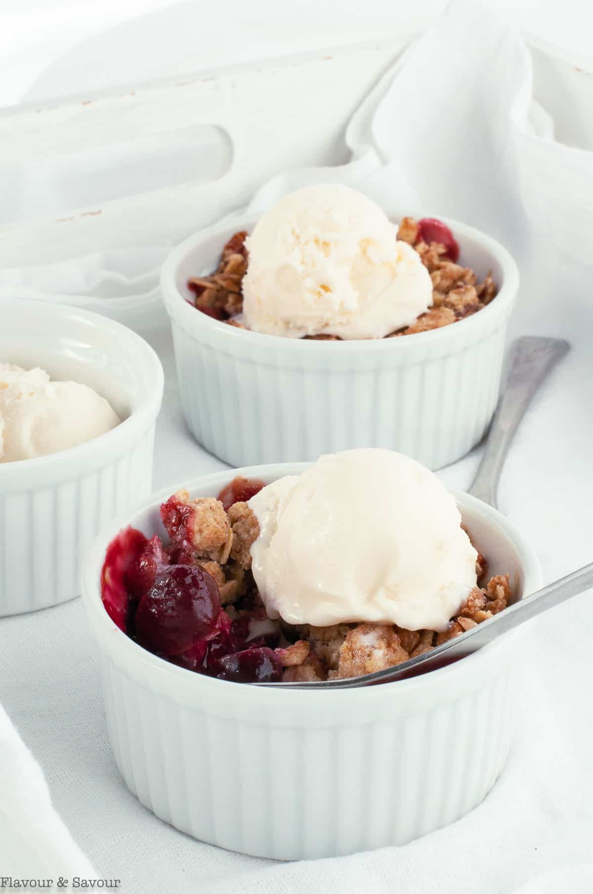 A spoonful of Air Fryer Cherry Almond Crisp with ice cream