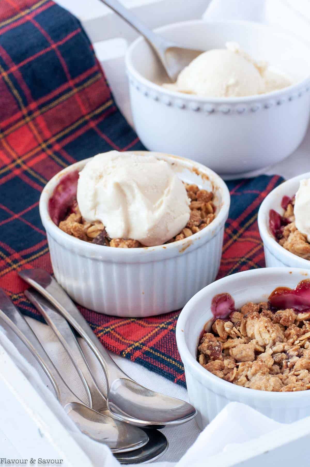 Close up view of mini Air Fryer Cherry Almond Crisp desserts in small white ramekins.