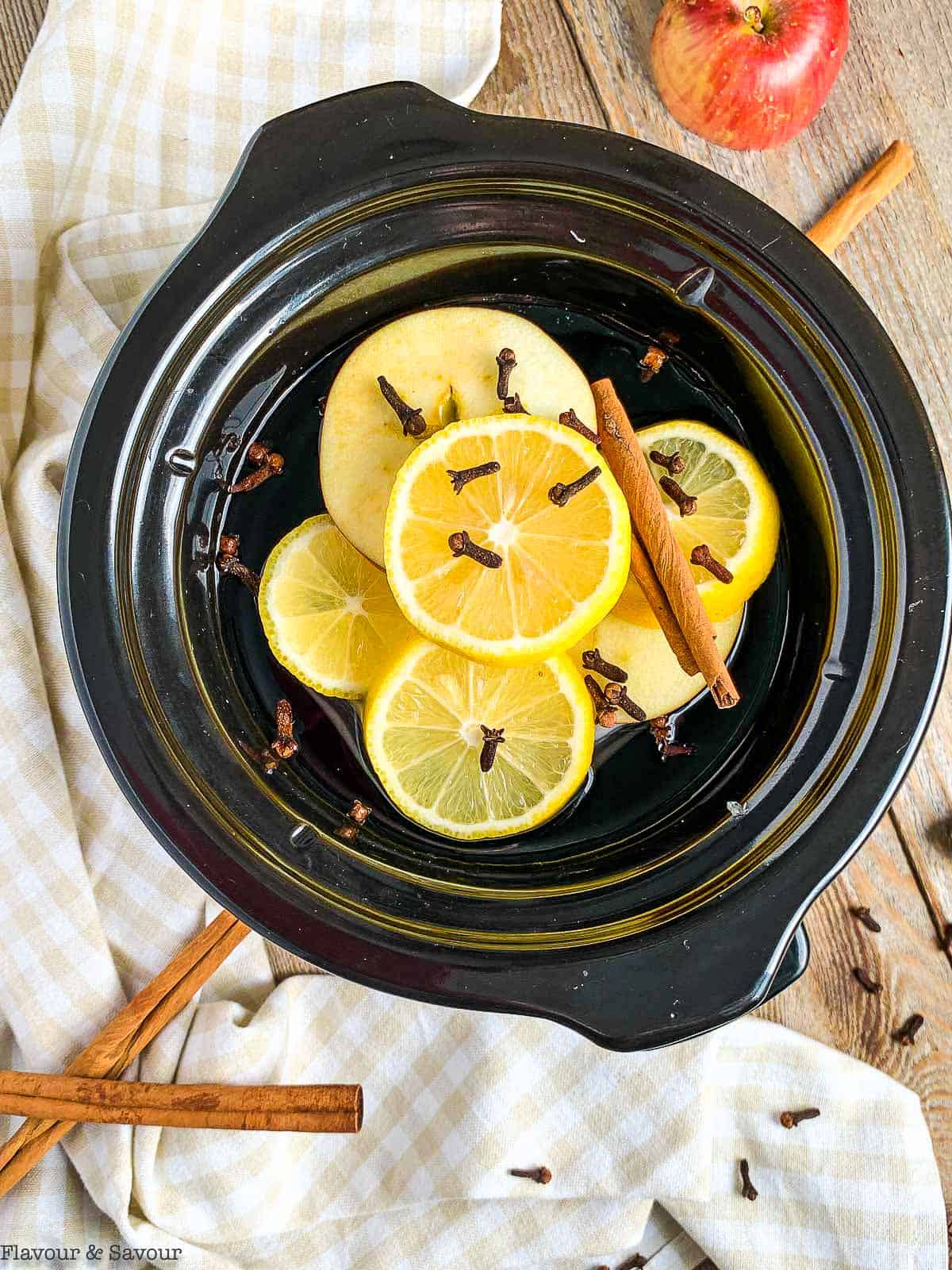 Close up view of Simmering Fall Potpourri with lemon slices and cinnamon sticks and cloves.