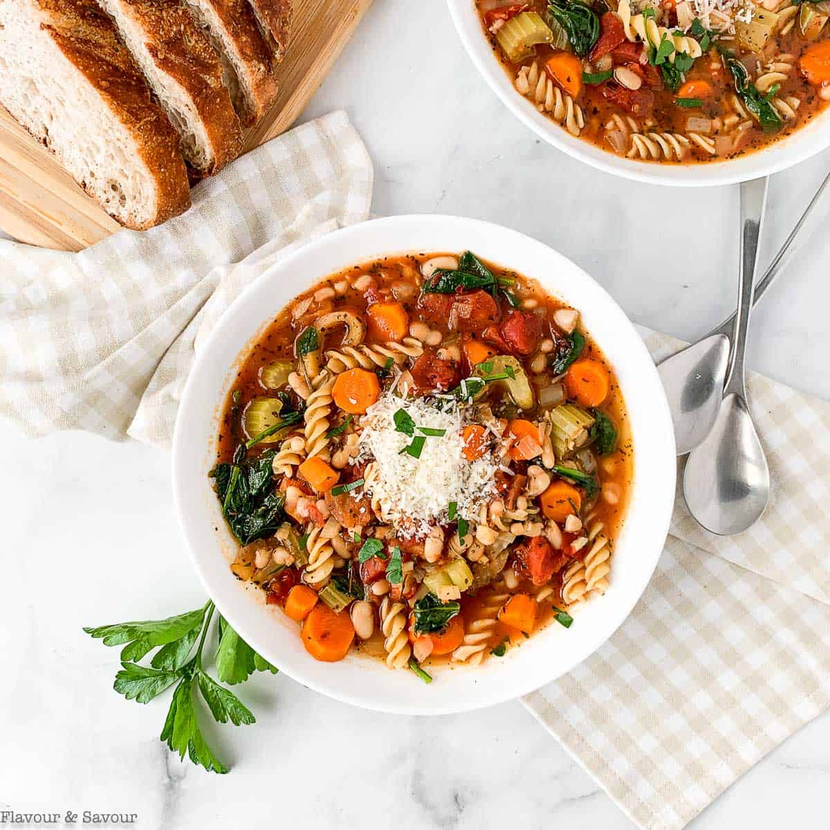 Overhead view of Instant Pot Minestrone soup with spinach, Parmesan cheese and chopped parsley.