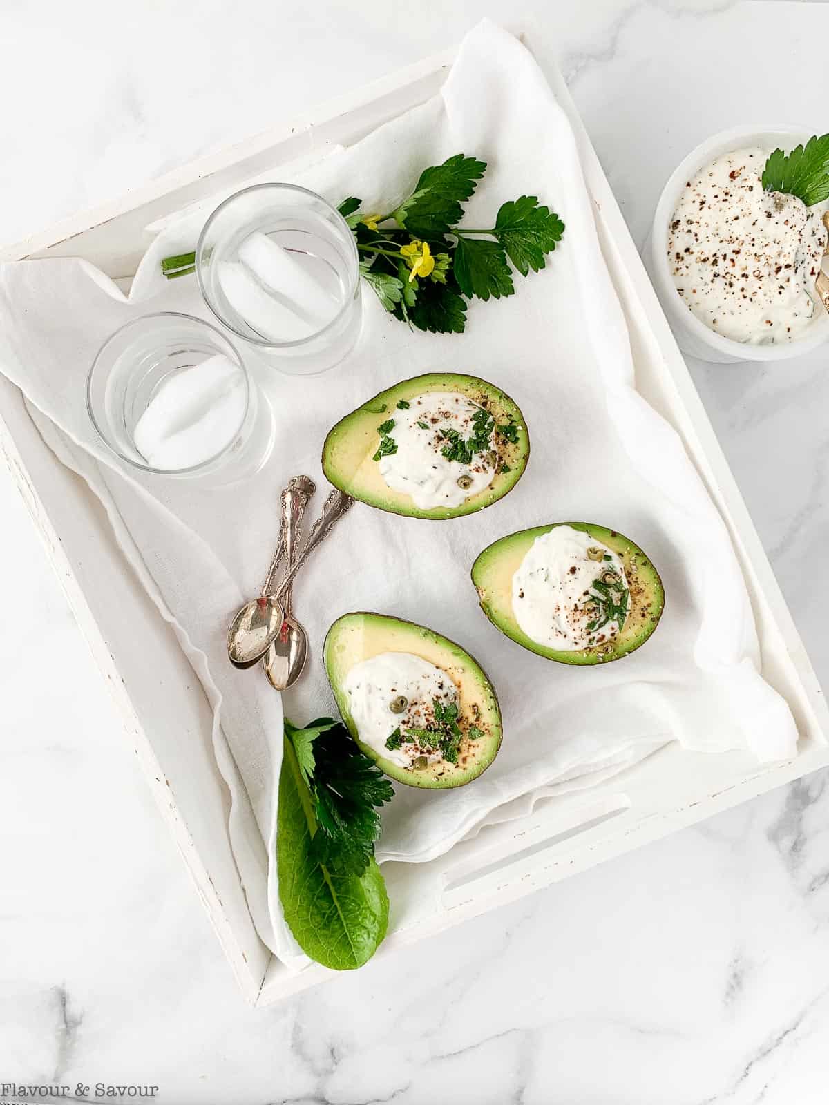 Stuffed Avocado with Creamy Herb Sour Cream Dip in a white tray