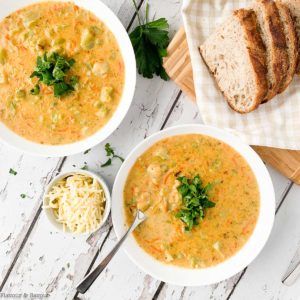 Two bowls of Broccoli White Cheddar Soup garnished with parsley