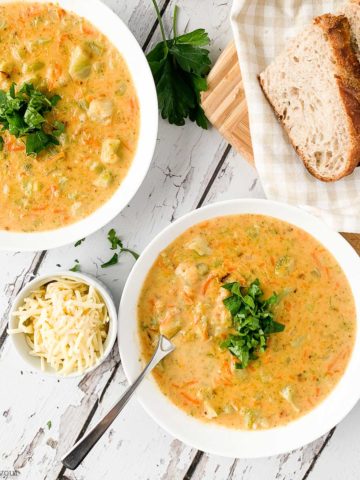 Two bowls of Broccoli White Cheddar Soup garnished with parsley