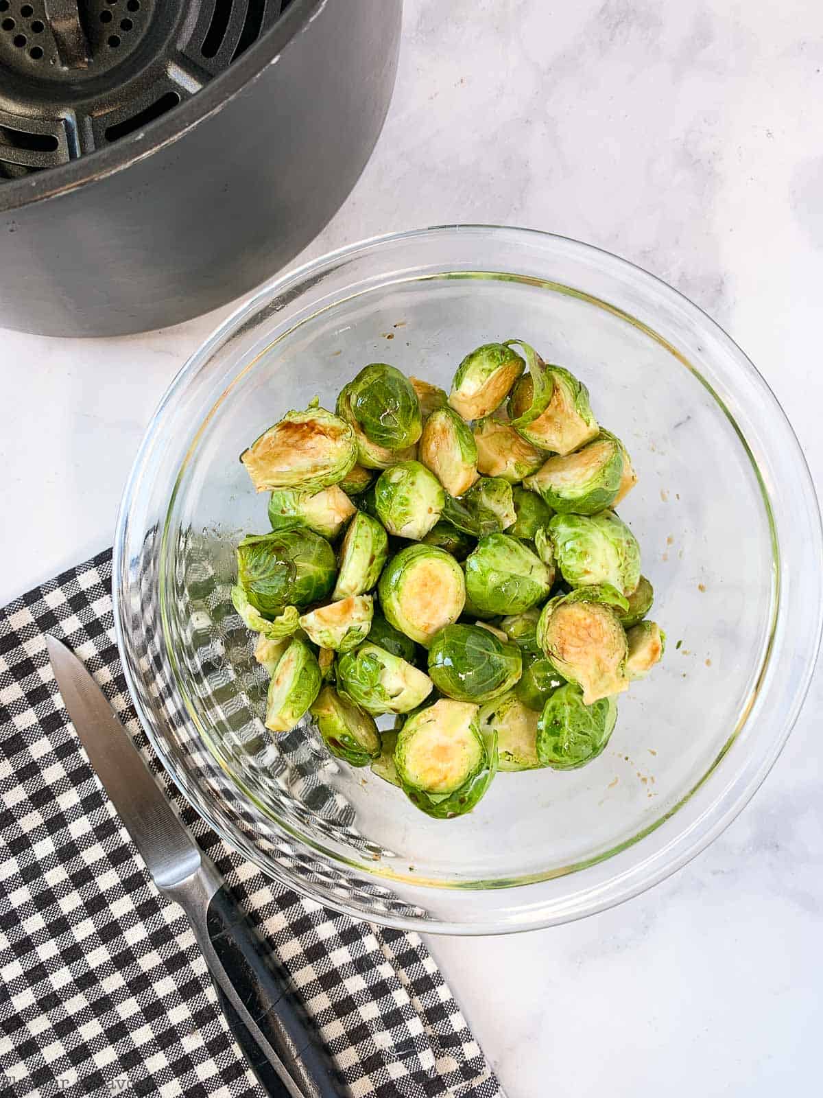 Brussels Sprouts in a bowl tossed with oil and balsamic vinegar