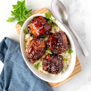 Overhead image of Instant Pot Sticky Chicken Thighs in a bowl with a serving spoon