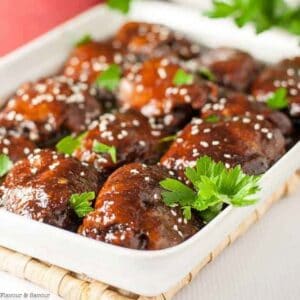 A serving dish with slow cooker Asian Sticky Chicken thighs.