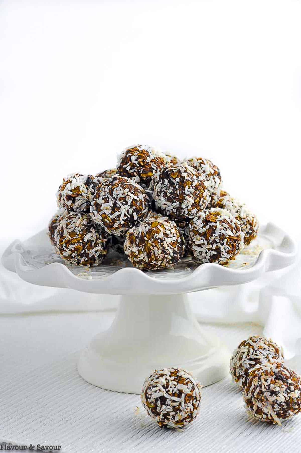 No-bake chocolate almond snowballs on a white pedestal cake plate.