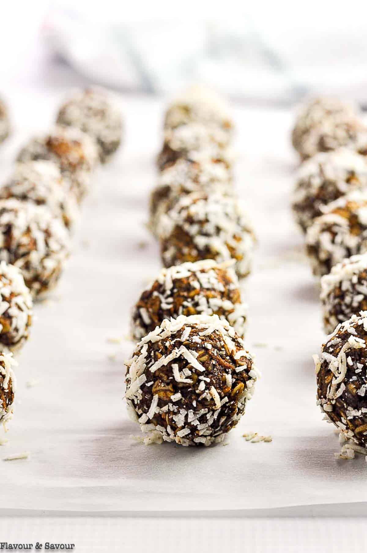 Rows of chocolate almond snowballs on a baking sheet.