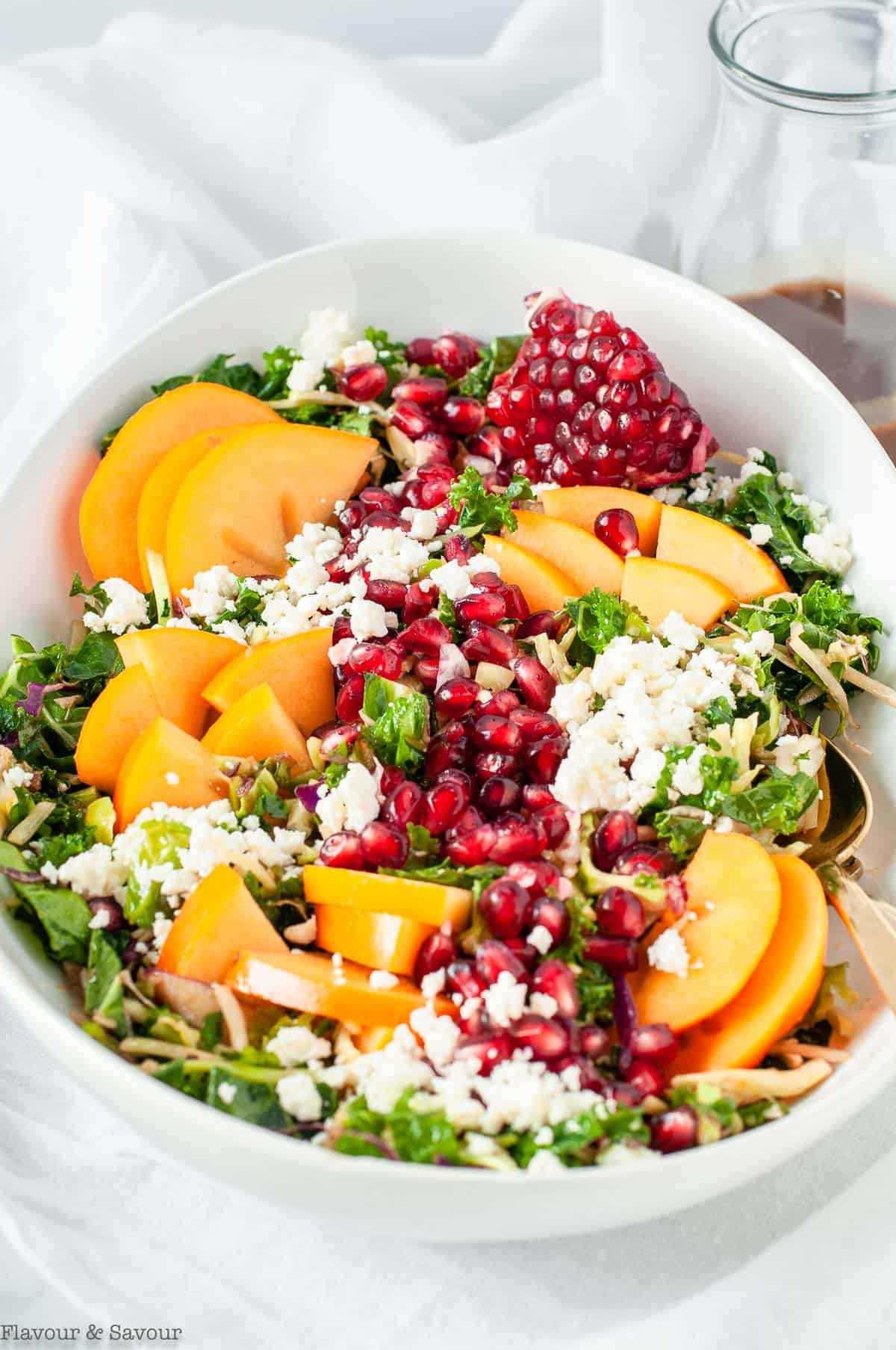 Winter Persimmon Kale Salad with pomegranate and feta cheese crumbles.