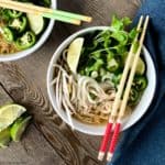 Overhead view of Chicken Pho with red chopsticks