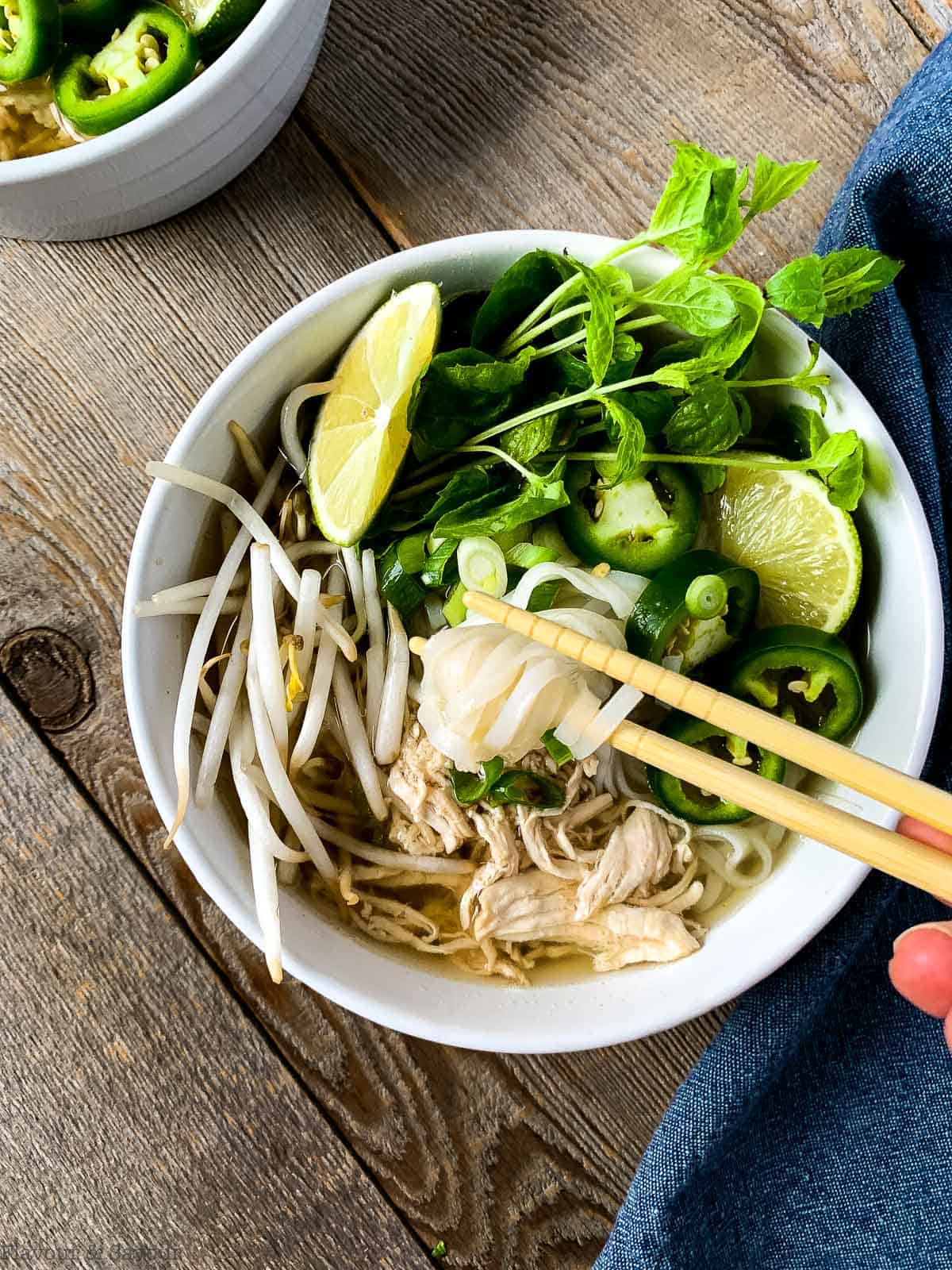 Lifting noodles from Vietnamese Chicken Noodle Soup (Pho
Ga) with chopsticks