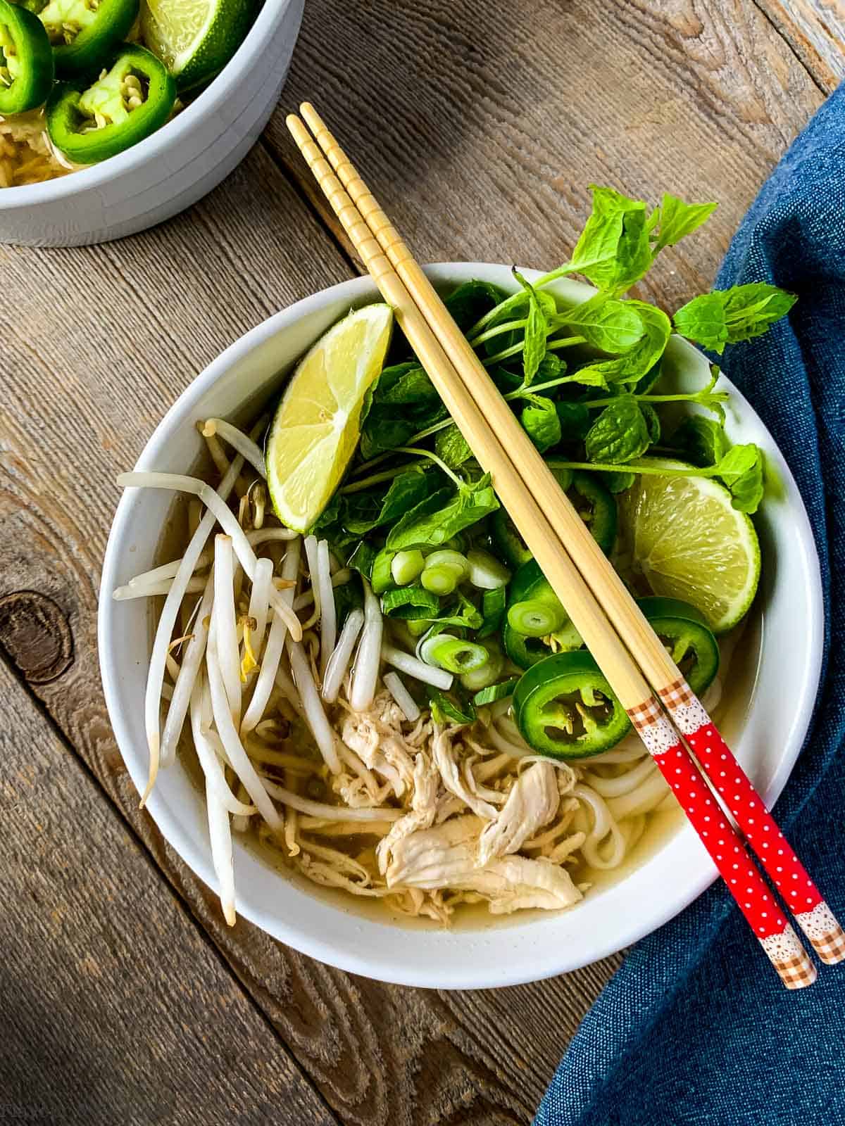 A bowl of Instant Pot Chicken Pho (Pho Ga) with chopsticks.