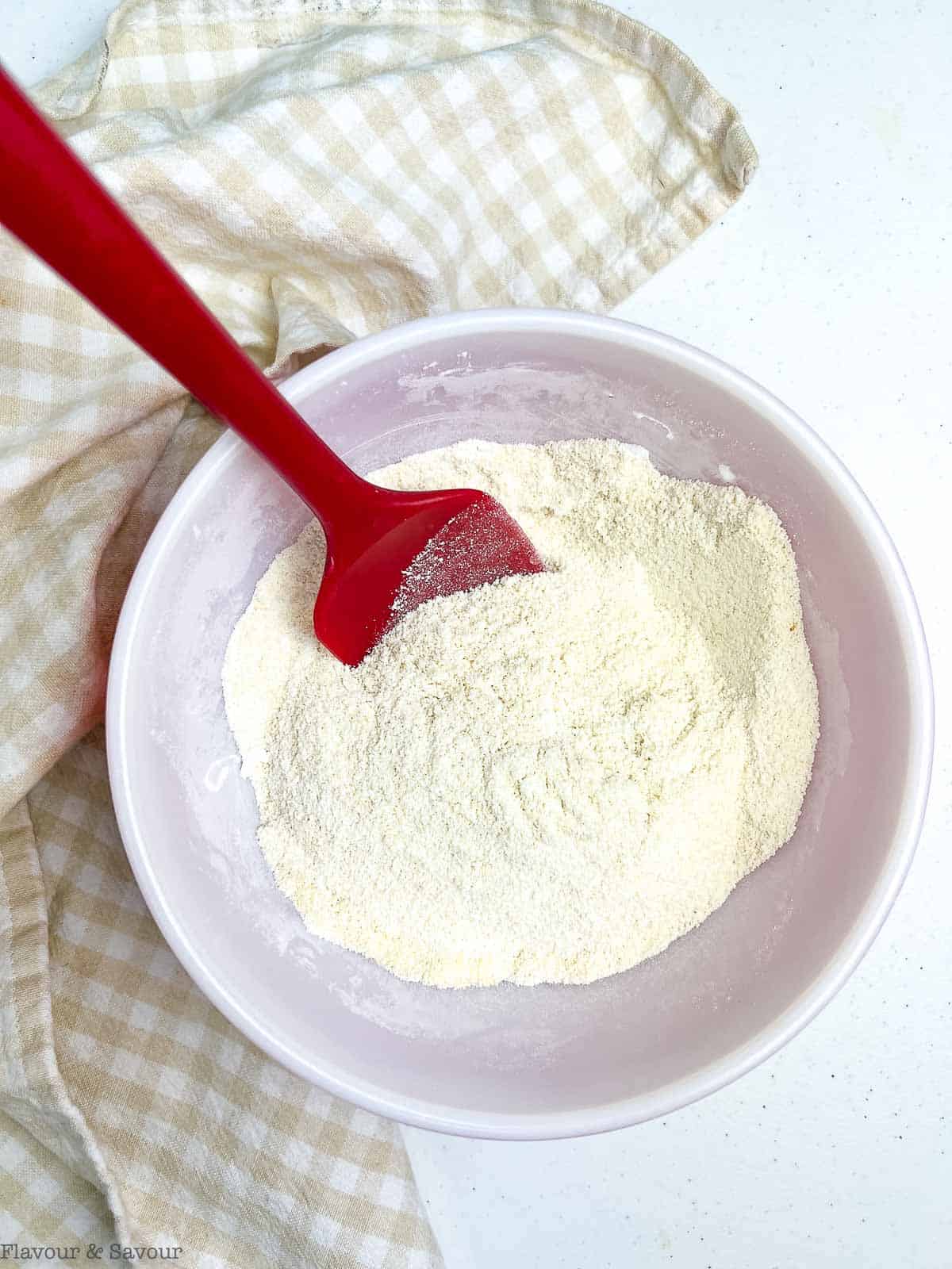 Dry ingredients for banana coffee cake in a bowl with a spatula.