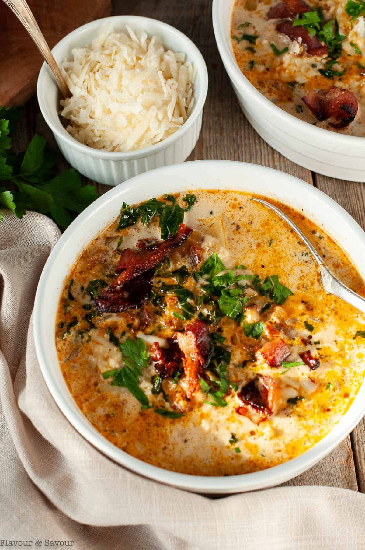 Zuppa Toscana or Instant Pot Tuscan soup bowls with a small bowl of Parmesan cheese