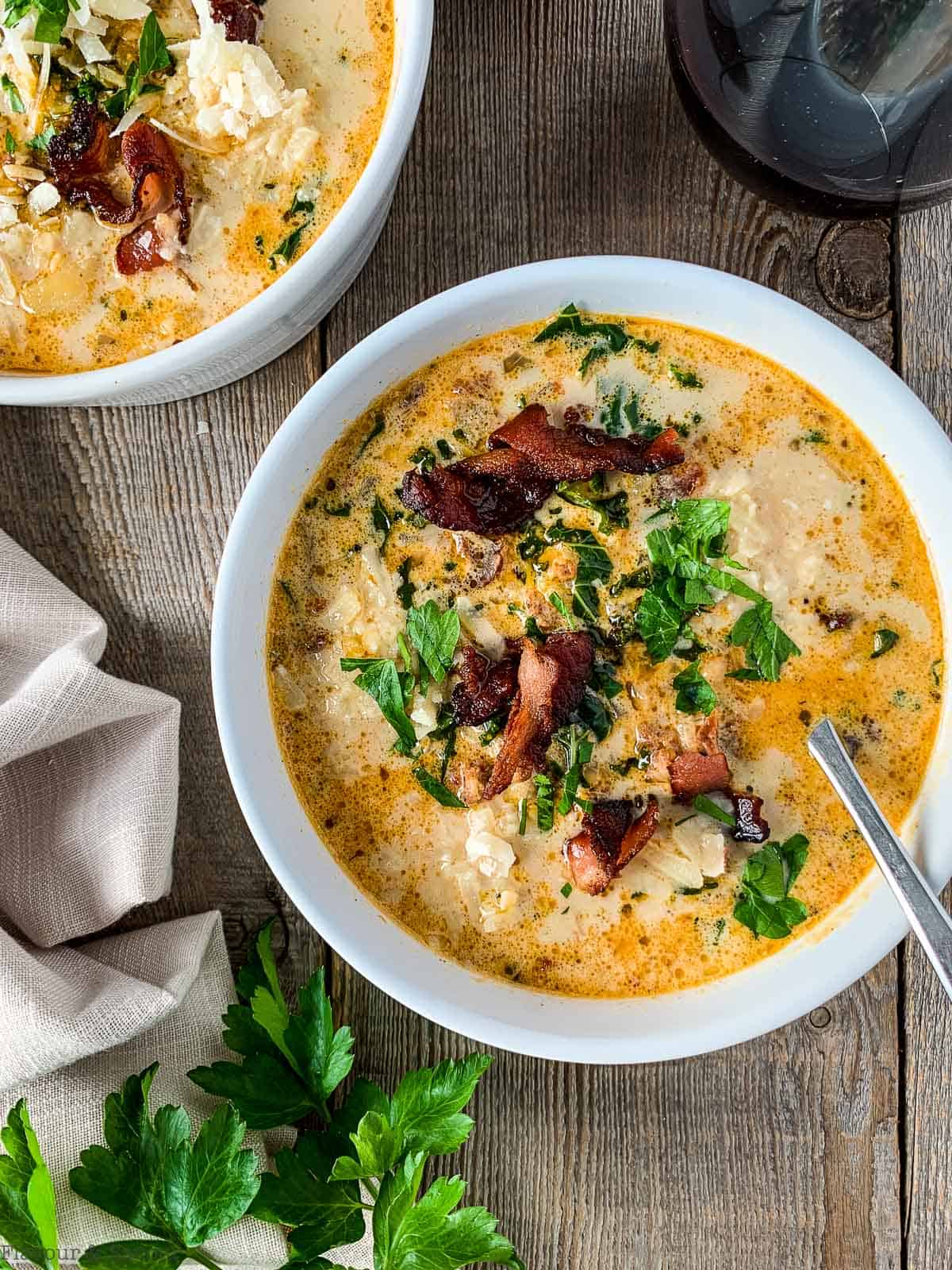 Overhead view of two bowls of sausage, potato and kale soup also called Zuppa Toscana made in an Instant Pot