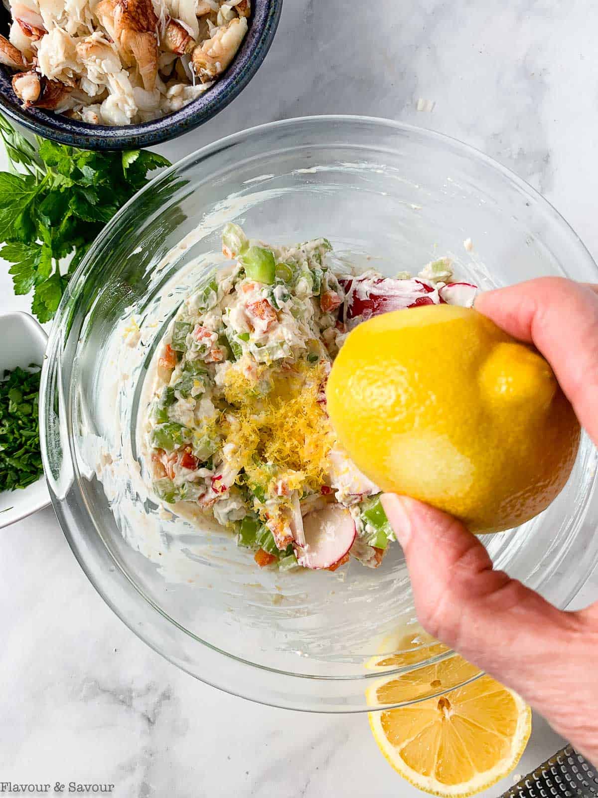 Squeezing lemon juice into cold crab dip.