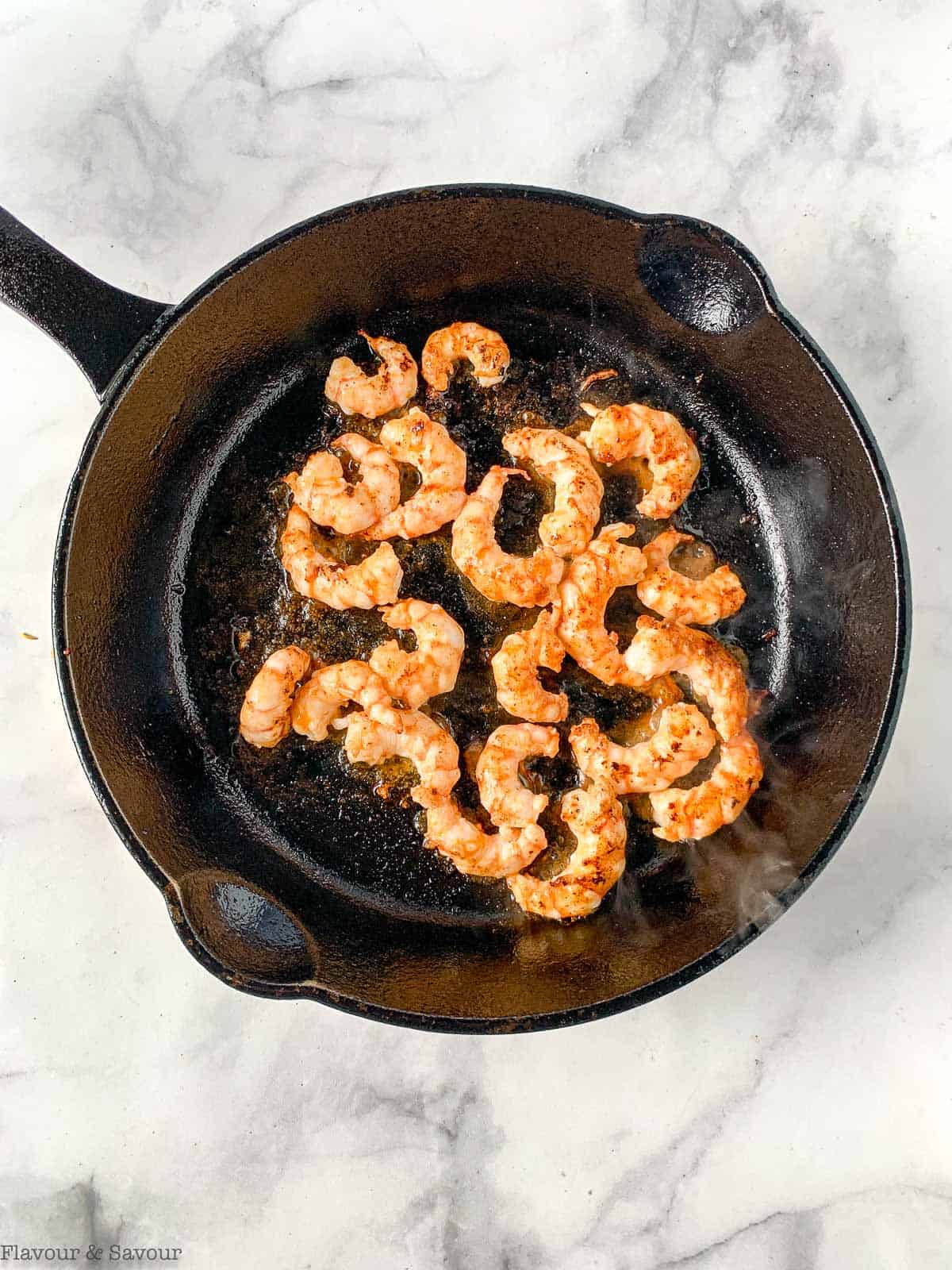 Shrimp in a cast iron pan.