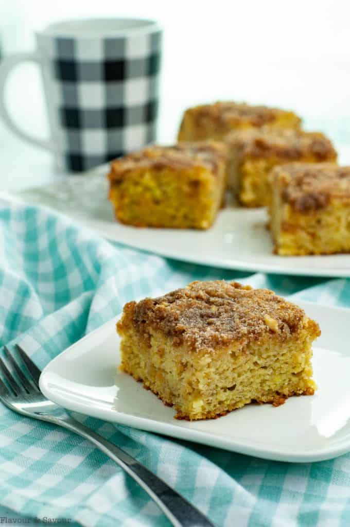 Banana Coffee Cake with streusel topping with a coffee cup in the background