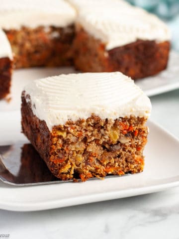 A square of grain-free carrot cake with cream cheese frosting .