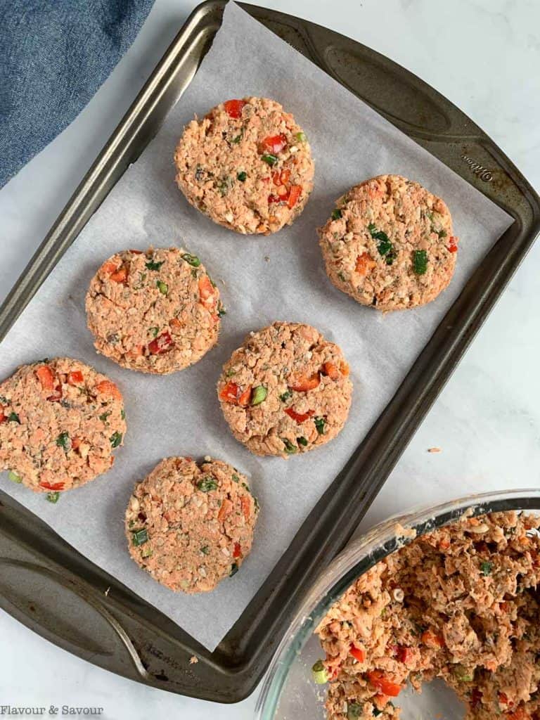 Salmon patties ready to freeze on a parchment paper lined baking sheet