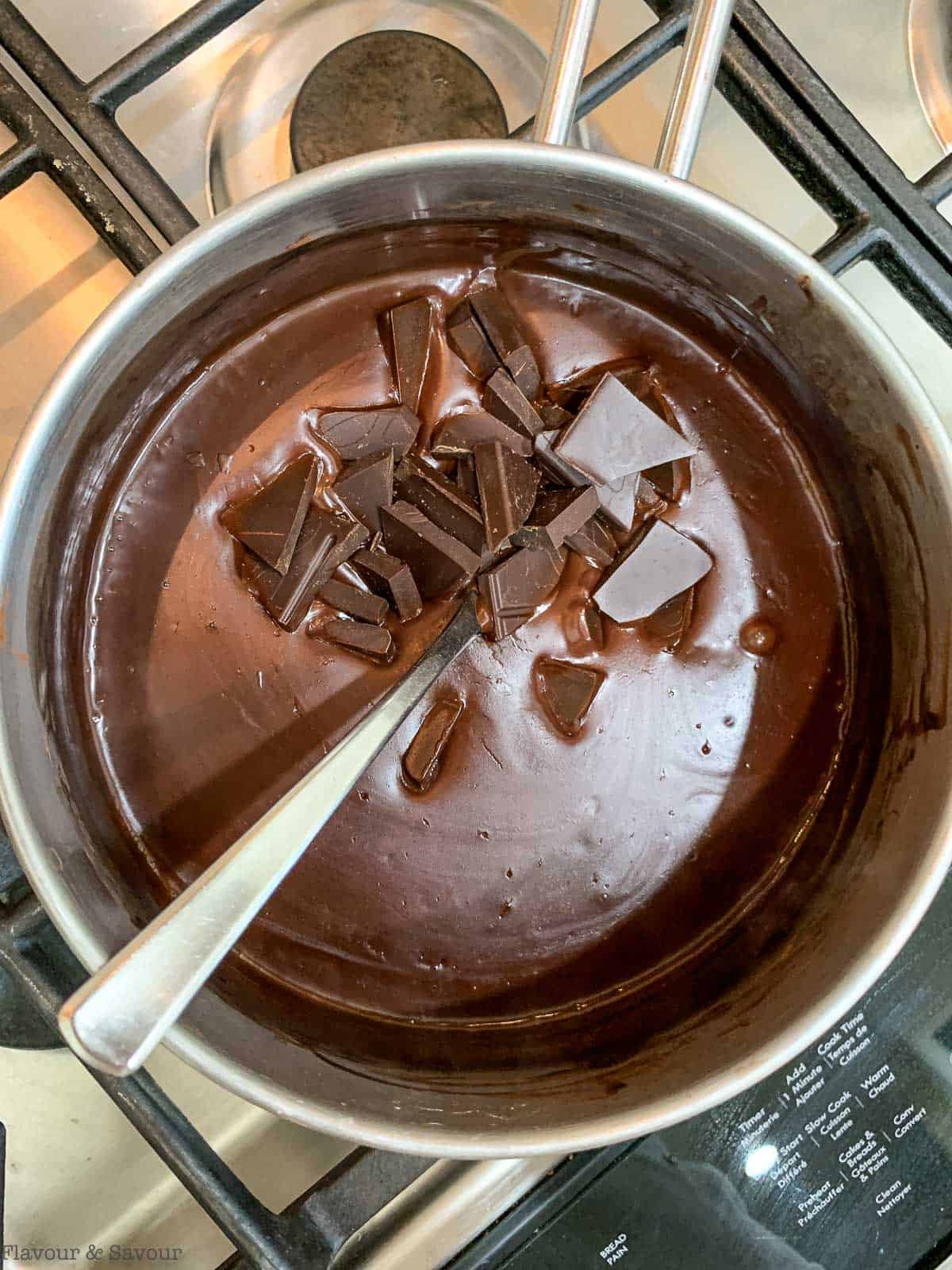Adding chocolate to pudding mixture.