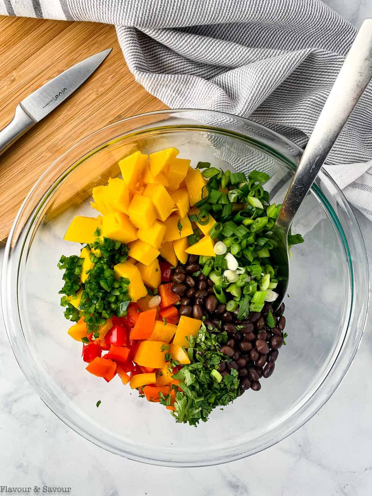 Mango black bean salad ingredients in a glass mixing bowl.