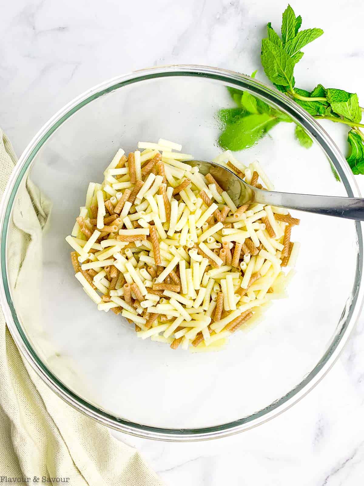 Pasta tossed with oil and salt for Tabouli Pasta Salad.