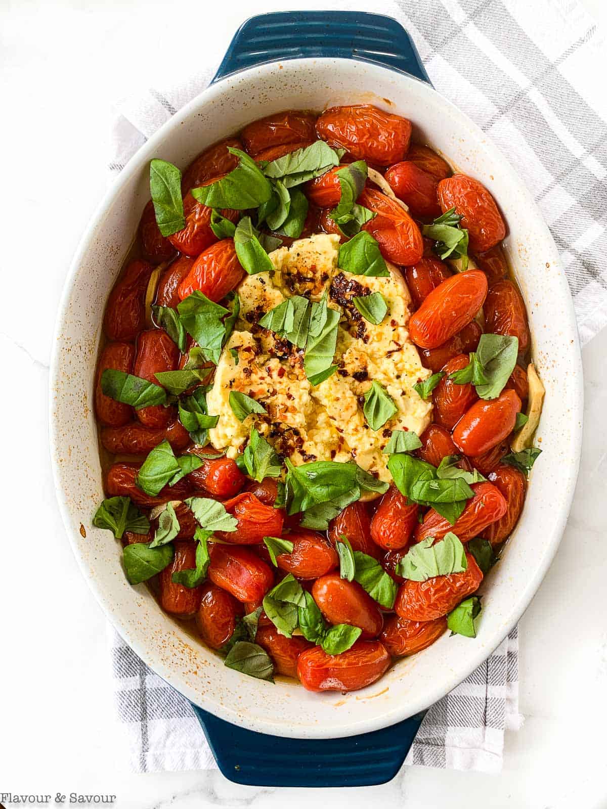 Adding basil to melted feta and burst tomatoes.