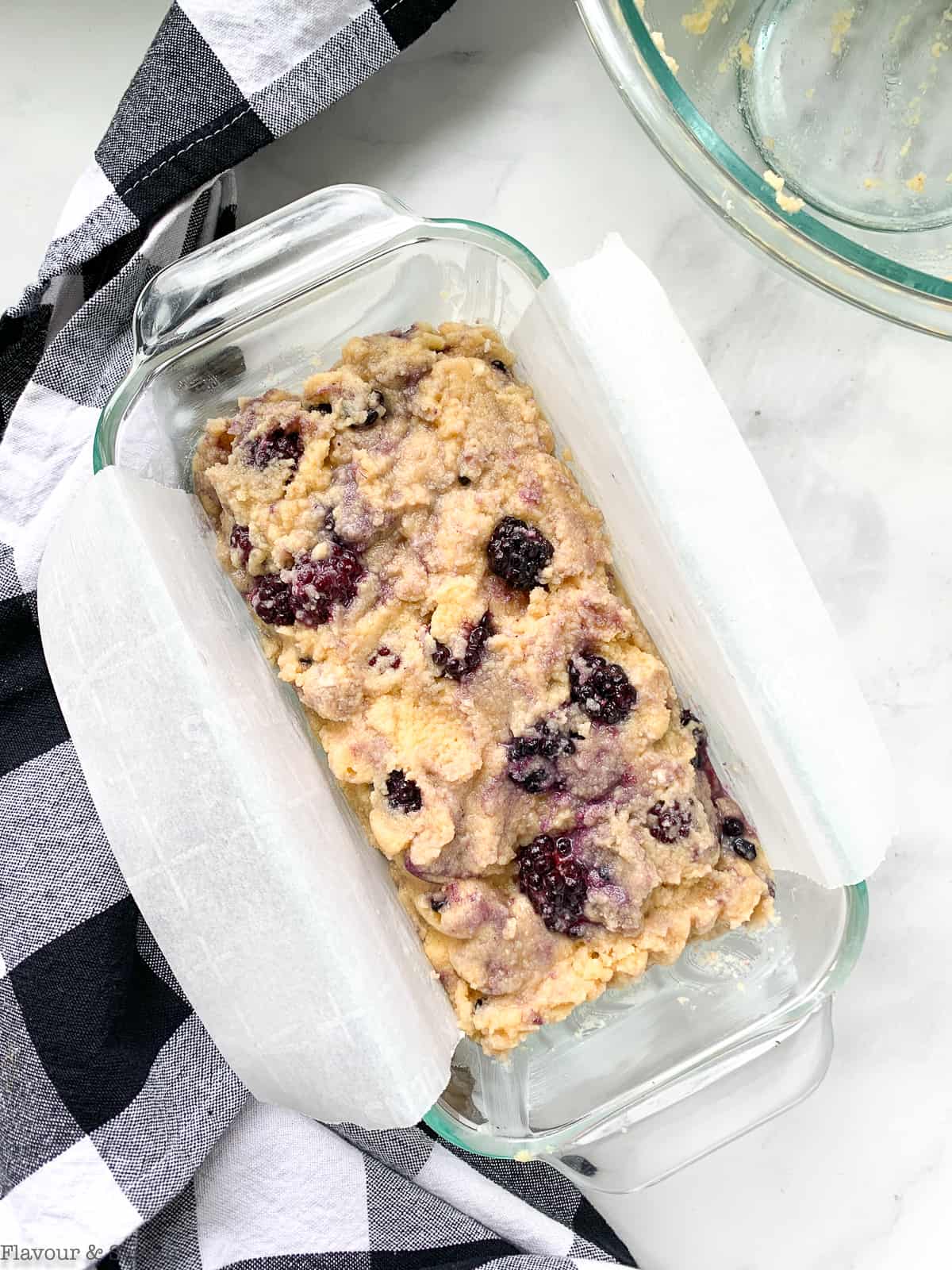 Blackberry loaf in a glass loaf pan ready to bake.