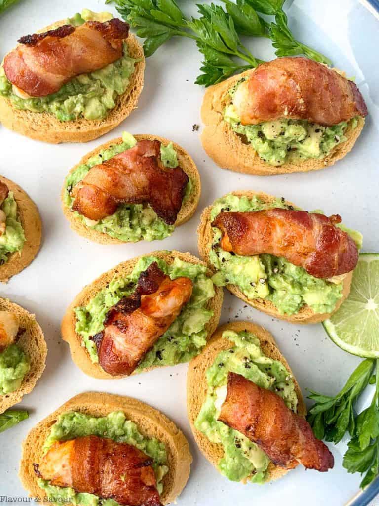 A platter of bacon-wrapped shrimp tapas on mini avocado toasts.