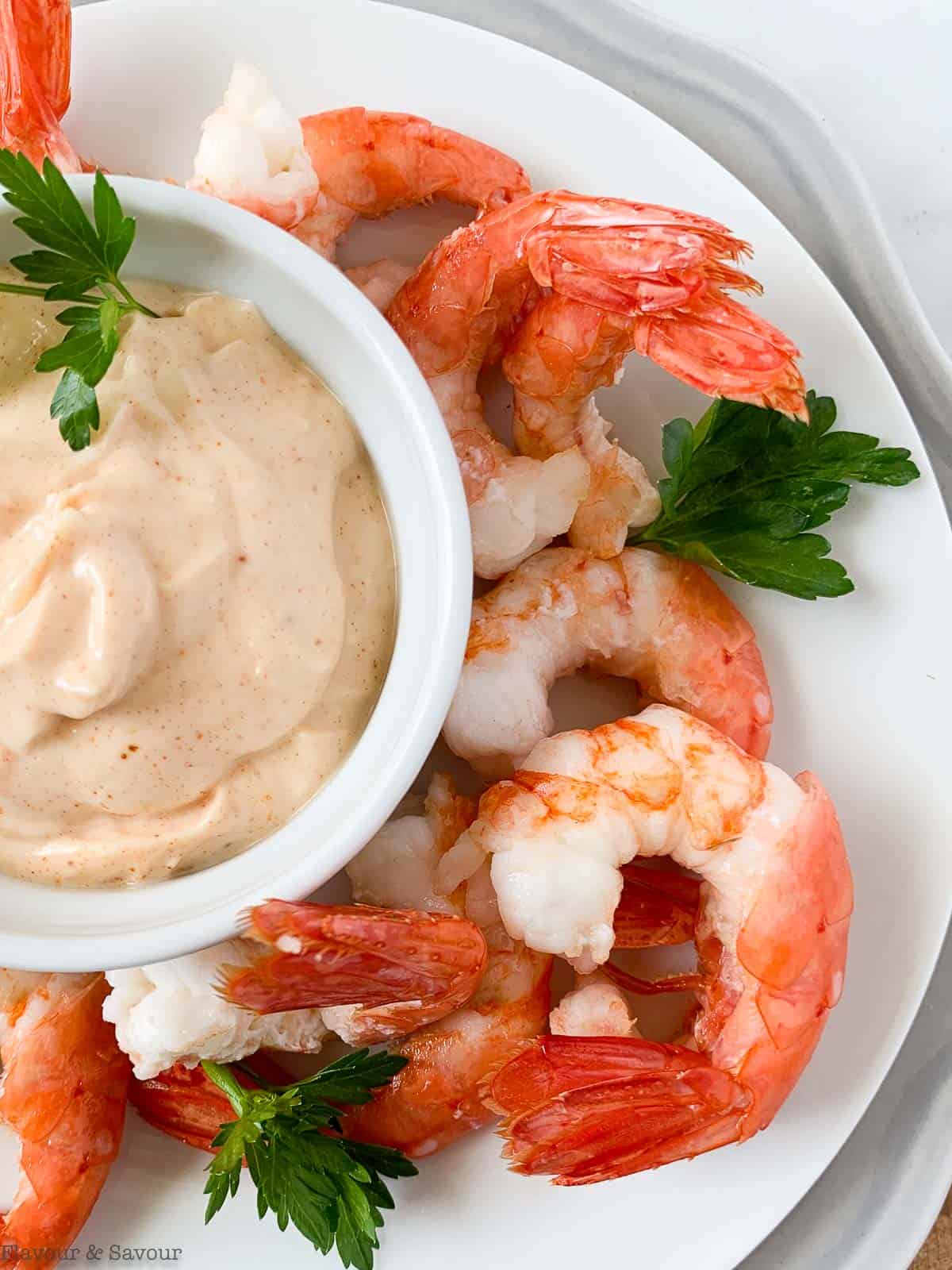 Air fryer lemon garlic shrimp with a bowl of dip.