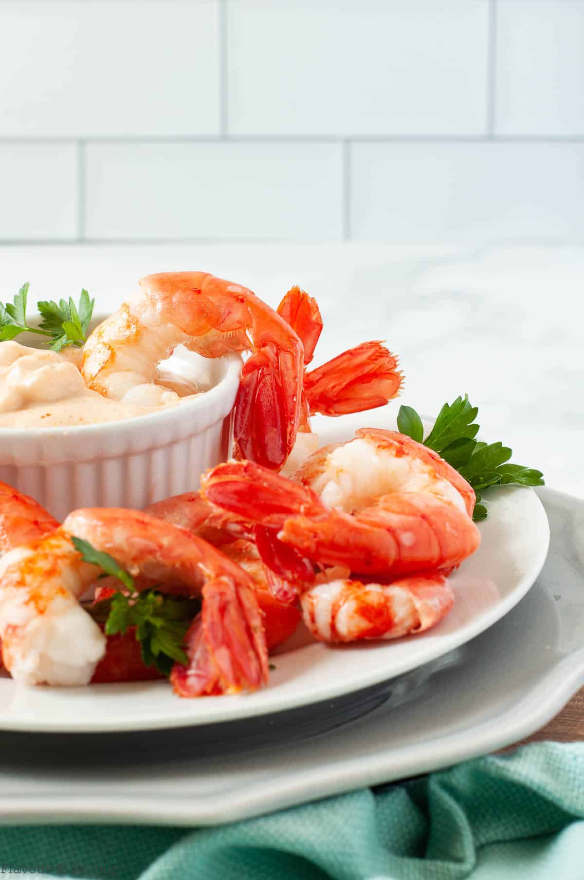 Side view of a plate of shrimp with dip.