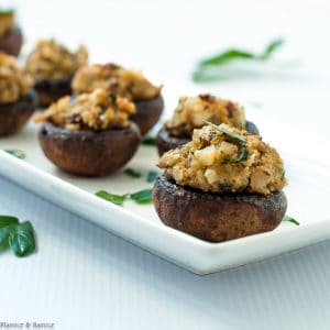 Mushrooms stuffed with blue cheese, garlic and herbs on a white narrow serving dish