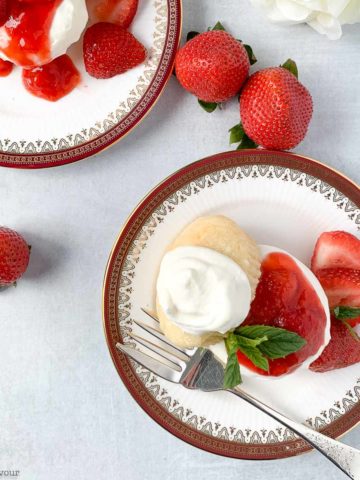 two plates of strawberry shortcake with whipped cream overhead view