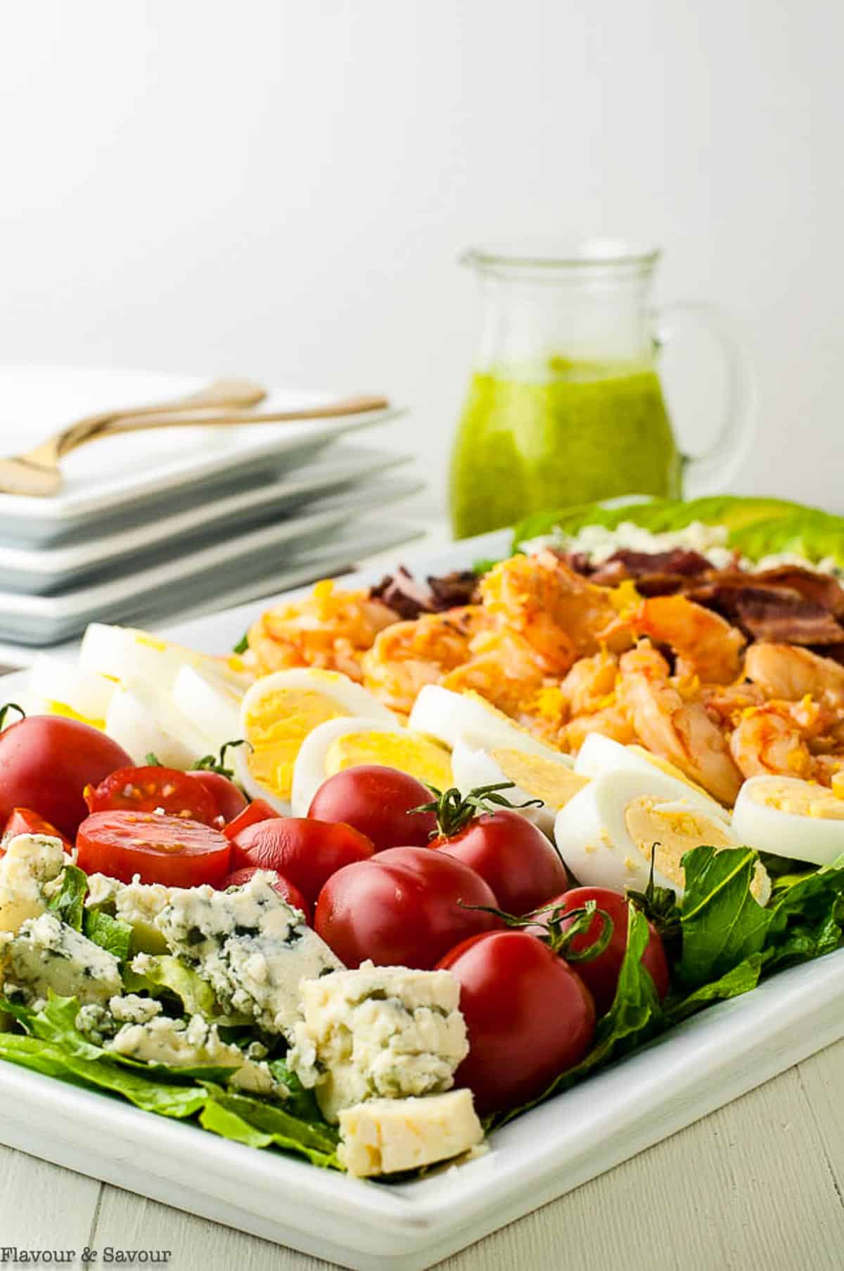 Lemon Garlic Shrimp Cobb Salad on a platter with a pitcher of dressing