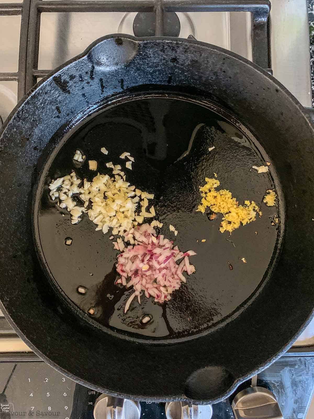 Garlic, shallots and ginger in a cast iron pan.