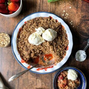 overhead view of gluten-free Strawberry Rhubarb Crisp in a baking dish with ice cream