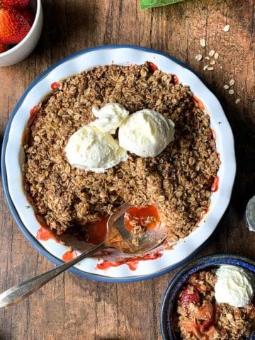 overhead view of gluten-free Strawberry Rhubarb Crisp in a baking dish with ice cream