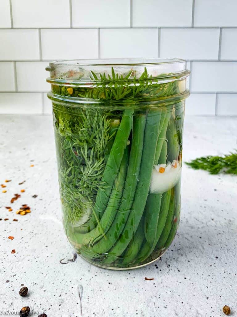 a jar of refrigerator pickled green beans on a countertop
