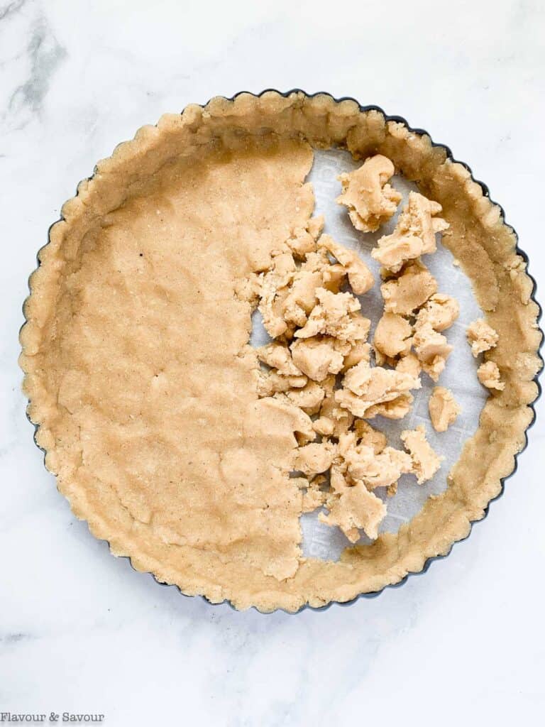 pressing dough into base of tart pan