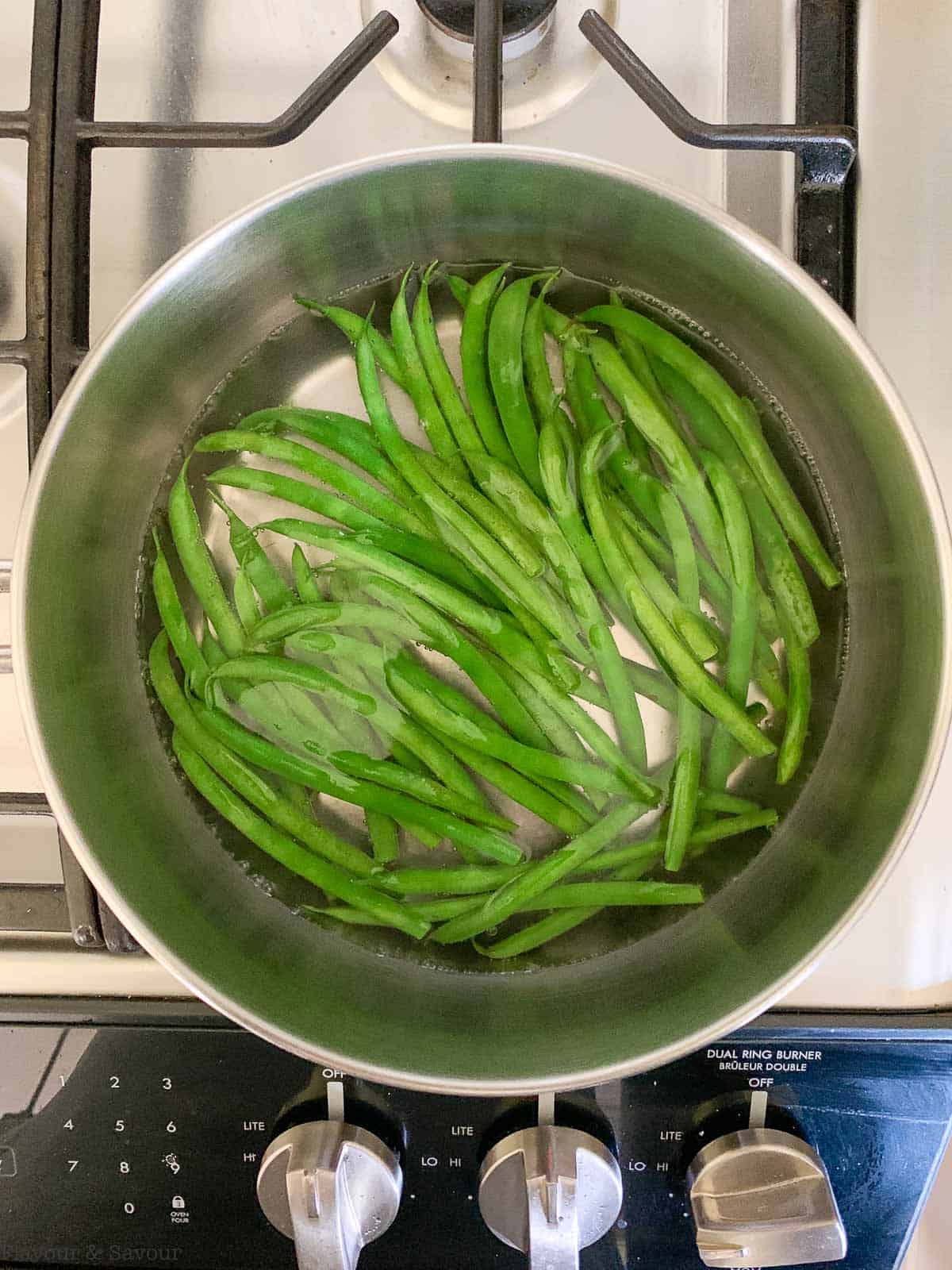 Blanching green beans in boiling water.