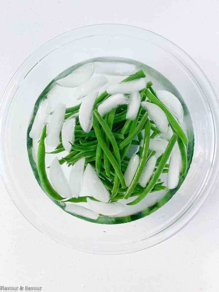 Green beans in a bowl of ice water.