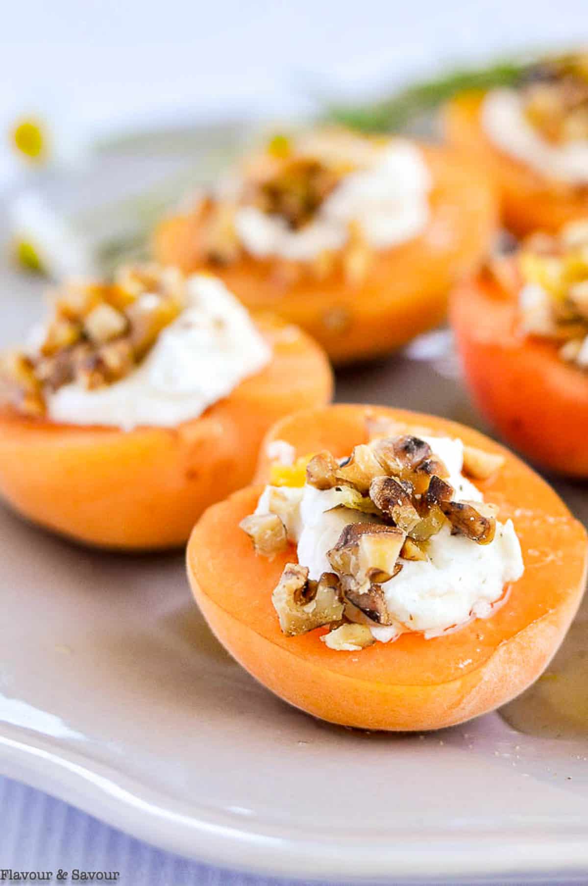 Close up view of fresh apricot appetizer with goat cheese and honey.