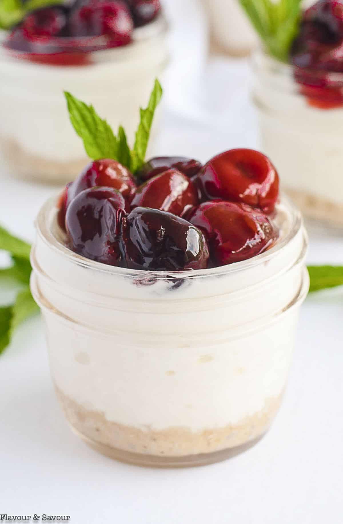 Close up view of a mini cherry cheesecake in a jar
