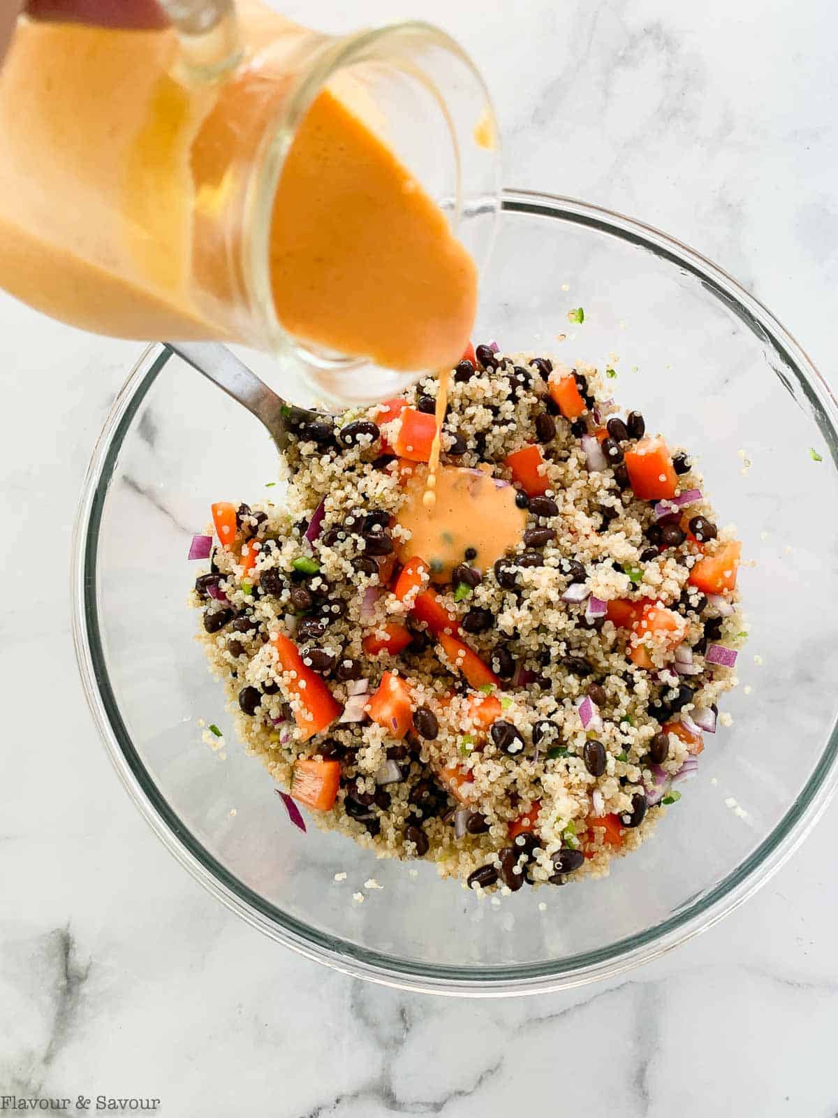 Pouring Sweet Peach dressing on black bean salad.