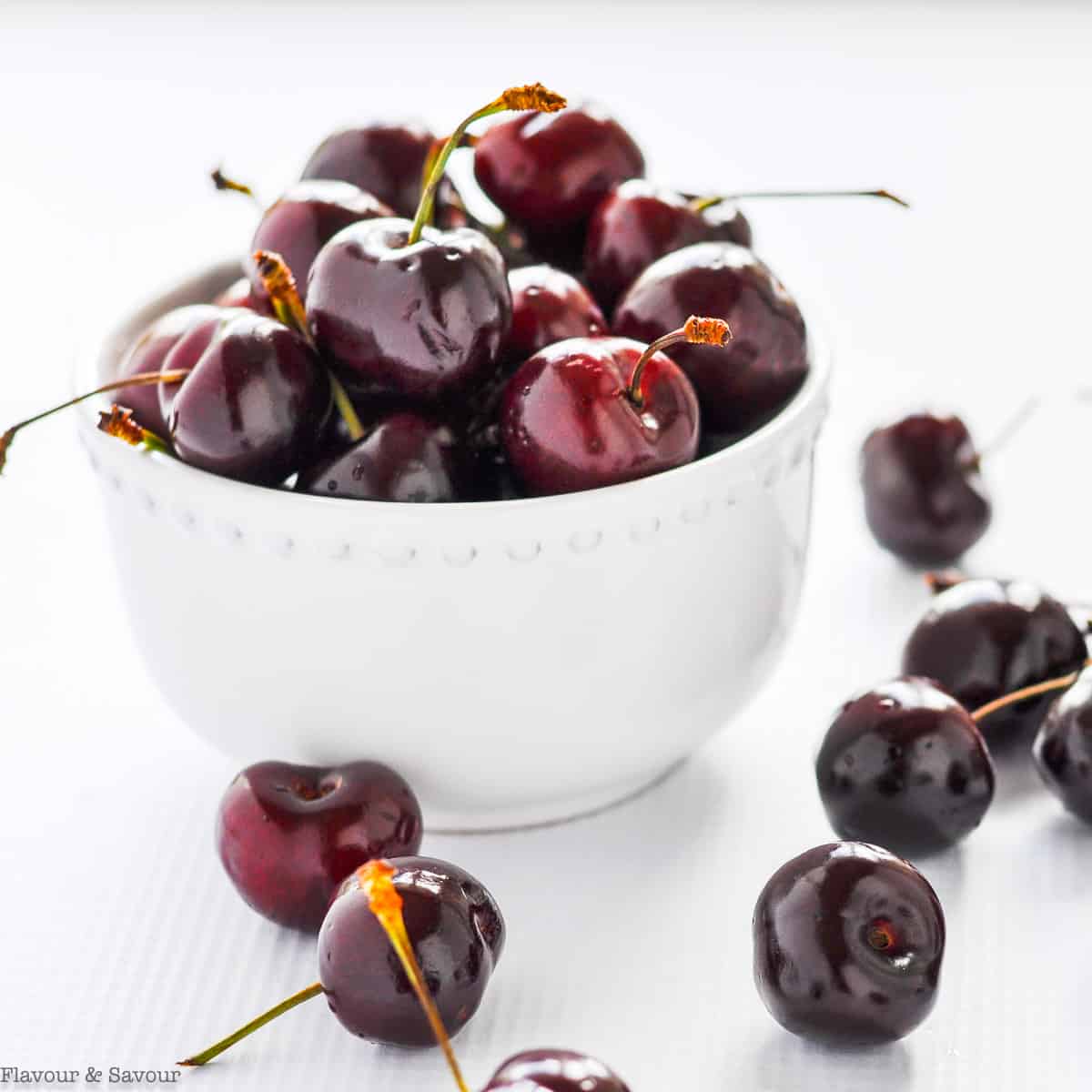 Fresh cherries in a small white bowl.